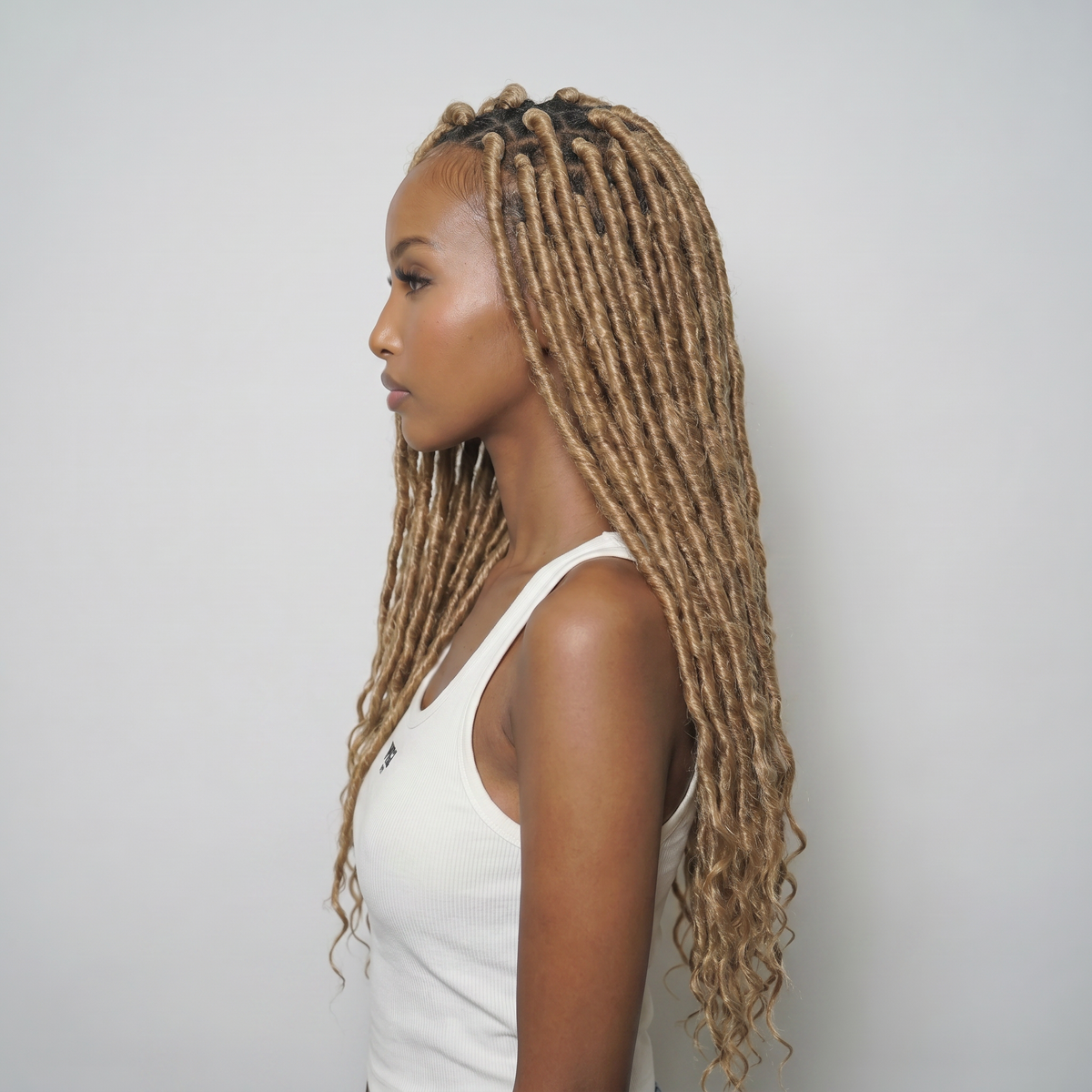 WIGZ 04 - Side profile view of layered AFRO ROOTED BLONDE LOCS virgin hair wig with WIGZ LAB CAP™.